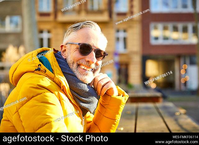 Portrait of smiling mature man wearing sunglasses in the city