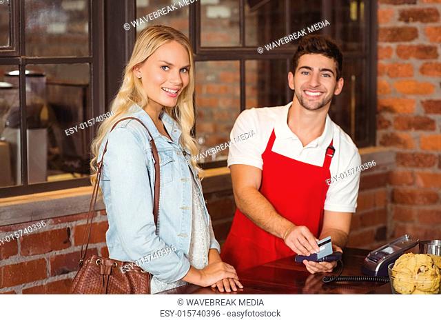 Smiling waiter swiping the credit card