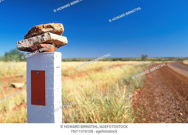 stones placed on a highway roadside post as a message to fellow aborigines