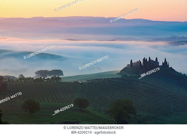 Podere Belvedere farmhouse, view of the Orcia Valley, at sunrise in the fog, San Quirico d'Orcia, Orcia Valley, Tuscany, Italy
