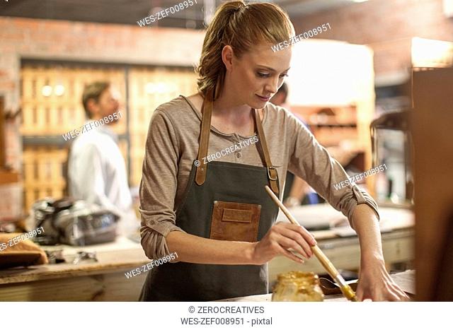 Young woman working in leather workshop