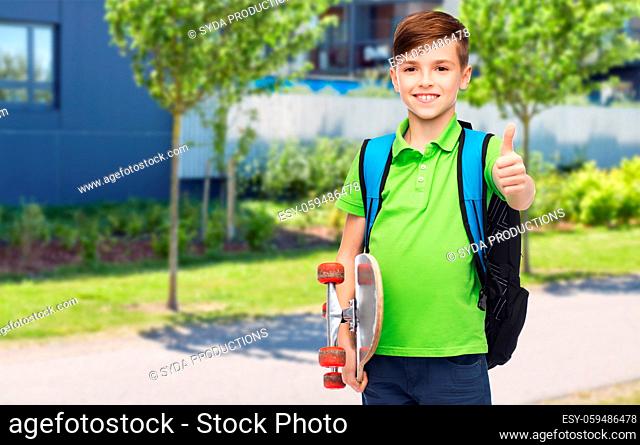 boy with backpack and skateboard showing thumbs up