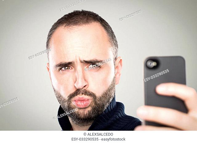 Young man taking a selfie with his phone