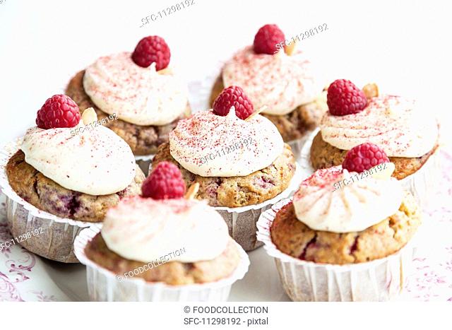 Raspberry and almond muffins decorated with buttercream and dried raspberry powder