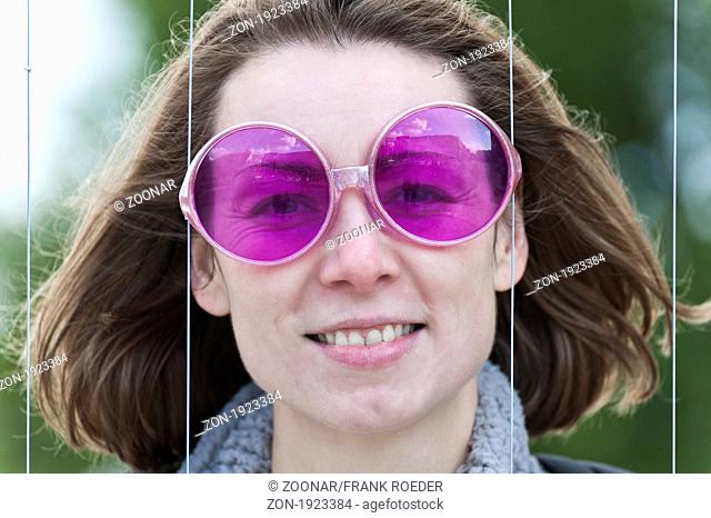 junge Frau mit pinkfarbener Sonnenbrille