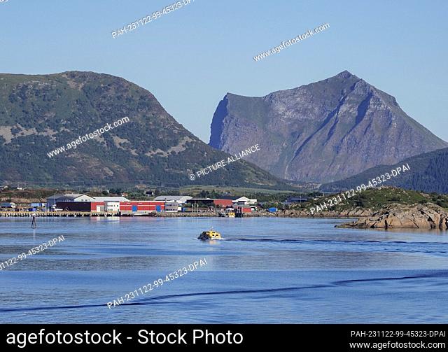 26 August 2023, Norway, Leknes: A yellow tender boat sails from a cruise ship moored in the bay towards the pier in Leknes harbor