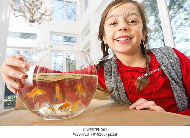 Germany, Bavaria, Grobenzell, Girl with goldfish bowl, smiling, portrait