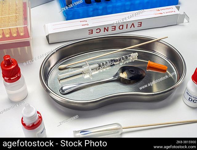 Syringe and spoon in police drug investigation department, concept image