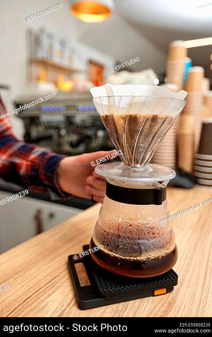 Professional barista man making coffee using filter at the coffee shop