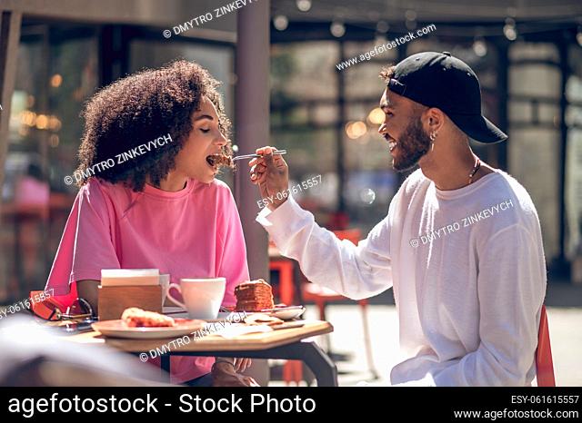 Happy couple. Couple in love feeding each other and looking happy