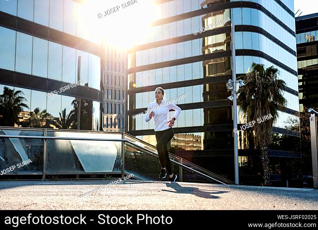 Woman jogging in front of modern building