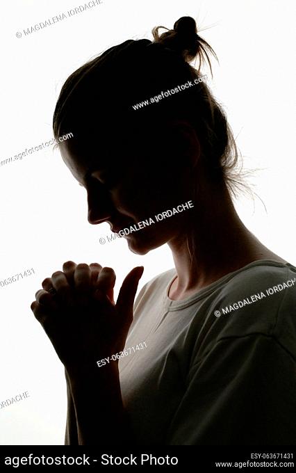 Closeup Profile Of A Woman Praying In Silhouette Isolated in Studio