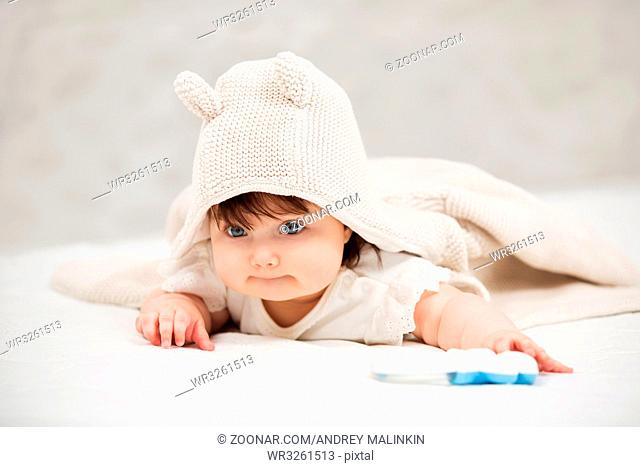 Portrait of baby girl crawling on blanket indoors