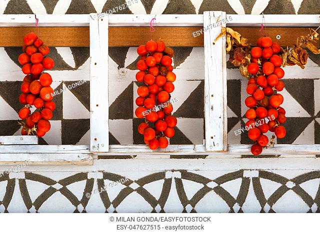 Tomatoes drying on a traditionally decorated wall of a house in Pyrgi village on Chios island, Greece.