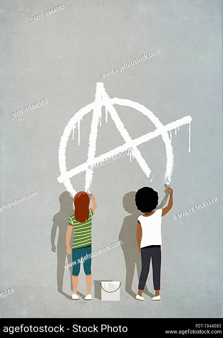 Girls painting anarchism symbol on gray wall