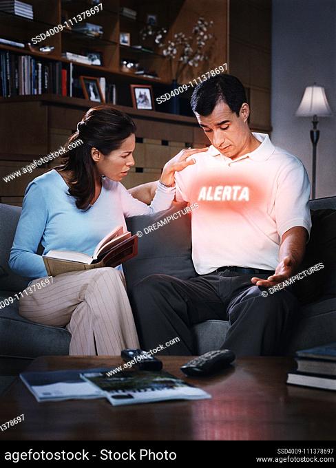 Hispanic woman looking at word on husband's shirt