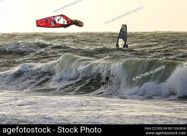 02 October 2022, Schleswig-Holstein, Westerland/Sylt: Marino Gil Gherardi (l) jumps during a competition in the Wave discipline