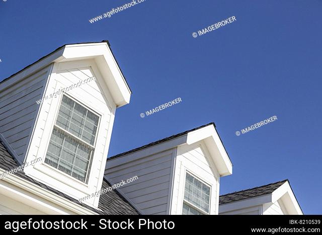 Roof of house and windows against beautiful deep blue sky