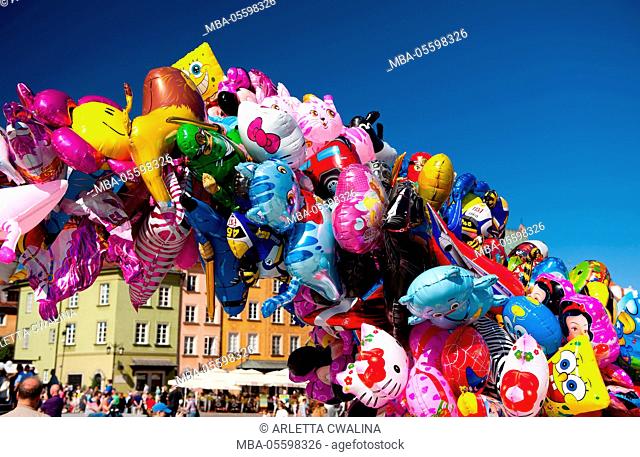 Colorful funny balloons at Old Town in Warsaw, tourists walking around, summertime in Poland