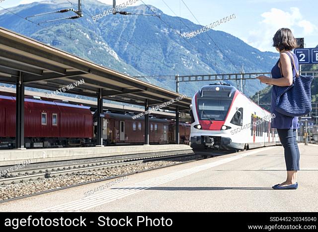 Woman on Railroad Station and a Train in Bellinzona, Ticino in Switzerland