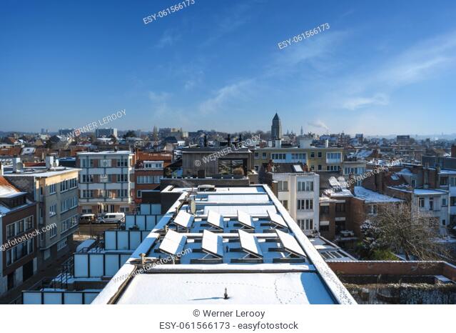 Jette, Brussels Capital Region -Belgium. Brussels skyline with snow on the rooftops in a residential area