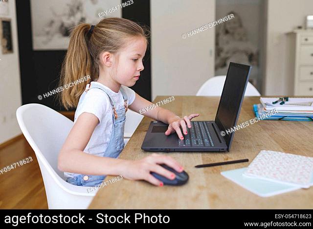 girl working on her laptop during home schooling during corona crisis