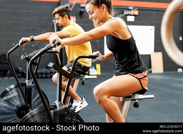 Couple exercising on bikes in gym