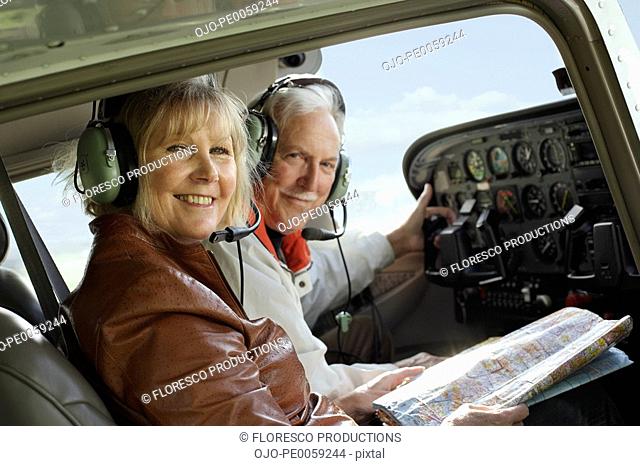 Couple in an airplane cockpit with a map