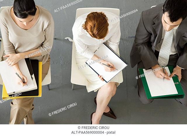 Business people taking notes during meeting