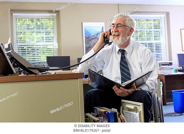 Caucasian businessman talking on phone at desk