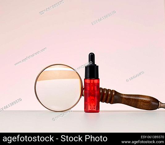 red glass bottle with pipette for cosmetics, oils and serum. Advertising and product promotion