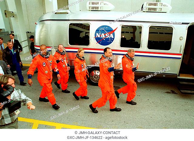 The STS-98 crew leaves the Operations and Checkout Building and heads for the Astrovan that will take them to Space Shuttle Atlantis on Launch Pad 39A