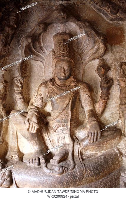 Sculpture of Vishnu seated on sesha in Lalitasana posture of royal ease on the cosmic snake shesha at Badami , Chalukya Cave , UNESCO World Heritage Site