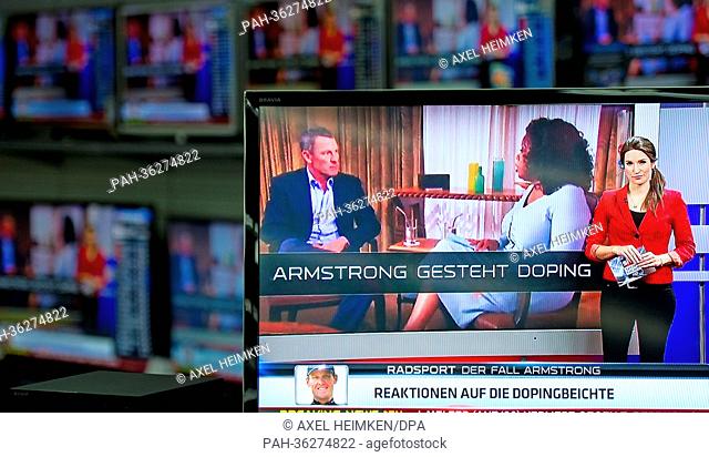 TV screens display US talkmaster Oprah Winfrey talking to former US cyclist Lance Armstrong in an early recorded interview