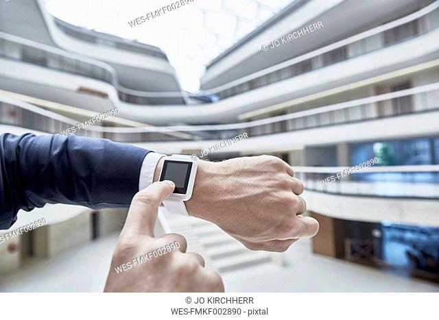 Businessman touching smartwatch in office building