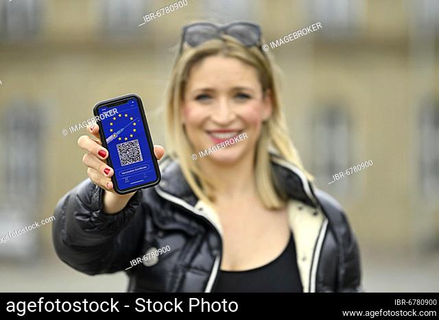 Symbol photo vaccination privileges, young woman holds smartphone with digital European vaccination card with QR code, Corona crisis, Germany, Europe