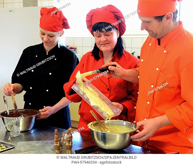 Company boss, Karin Finger (C), head chef, Marko Schnitter, and chef, Viktoria Steinwachs, prepare various chocolates for pralines and edible high heels in the...