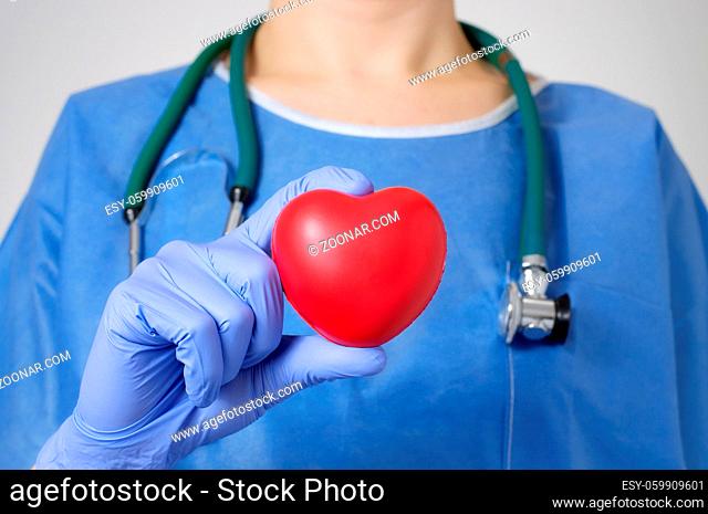 Red heart in the hand of a doctor