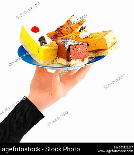Hand giving plate with cakes isolated on white background