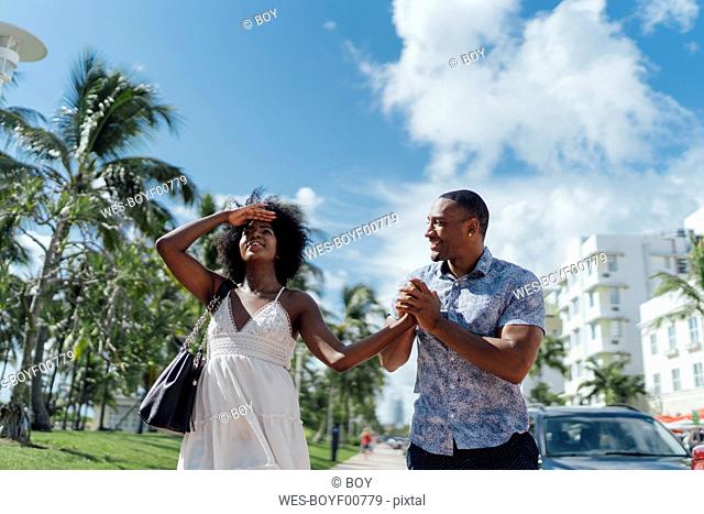 USA, Florida, Miami Beach, happy young couple walking down the road together