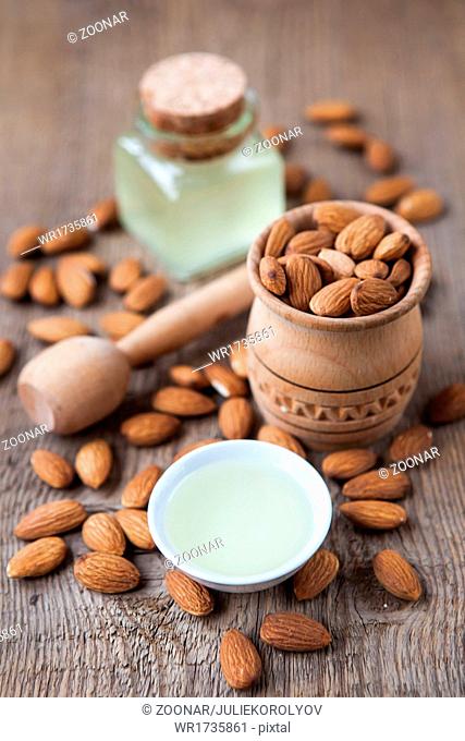 almonds oil and nuts on a wooden background