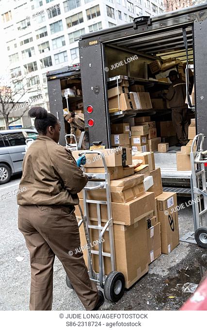 Female UPS Driver/Employee Unloading Packages from a UPS Truck, on Third Avenue, Manhattan, New York City