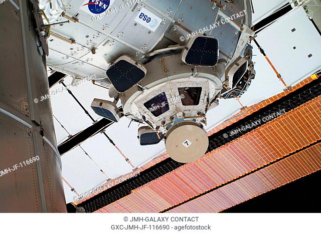 This is a high angle view showing the Cupola, backdropped against a solar array panel, on the International Space Station