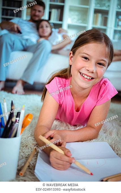 Girl lying on the floor and drawing