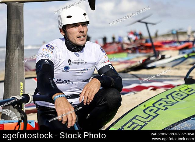 25 September 2022, Schleswig-Holstein, Westerland: Nico Prien from Kiel sits on the beach after a regatta. At the Windsurf World Cup off Westerland on the...