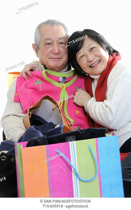 Senior asian couple having fun shopping