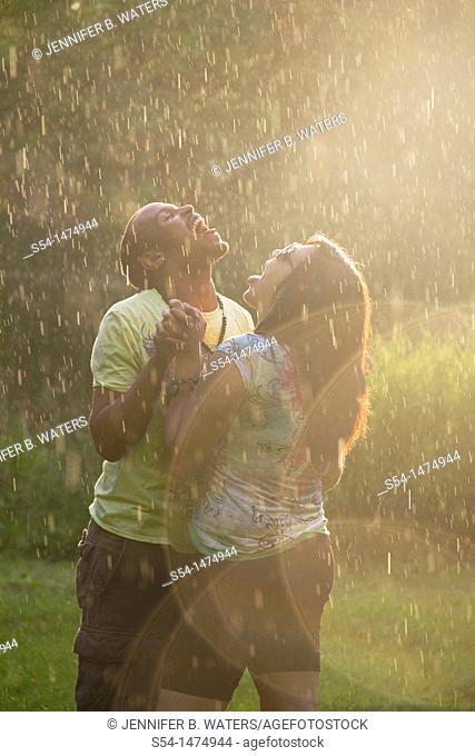 A happy, young, african-american couple playing in the rain