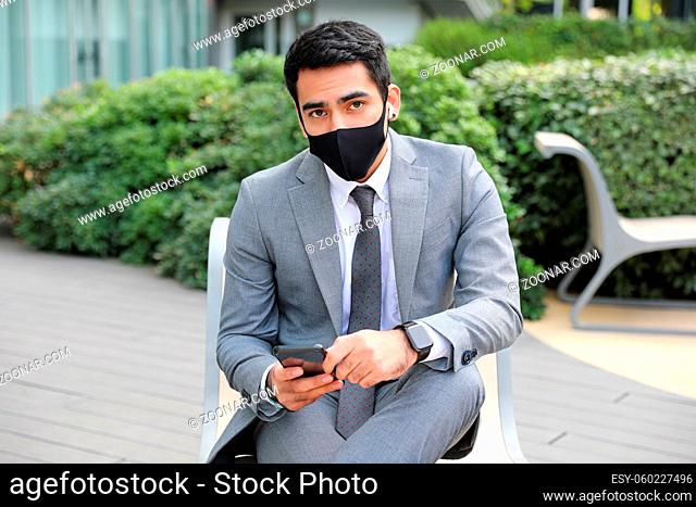 Young business man wearing black face mask. Outdoor headshot. High quality photo