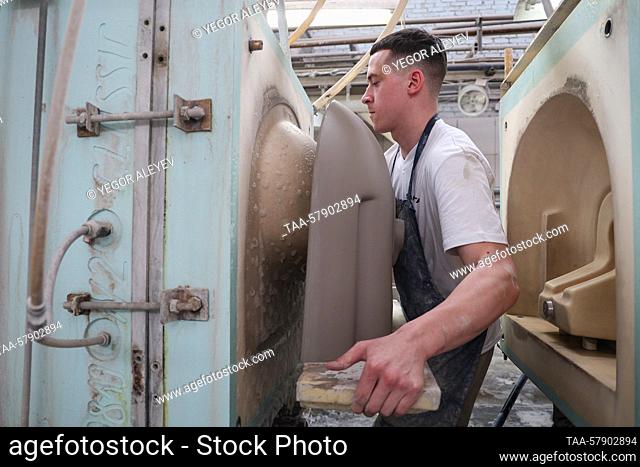 RUSSIA, SAMARA REGION - MARCH 15, 2023: A man handles sinks cast at the Samara Stroyfarfor factory in the rural town of Stroykeramika, 20km northeast of Samara