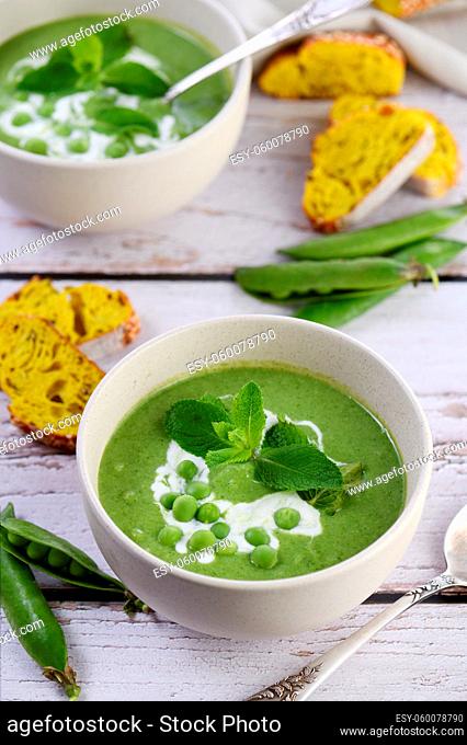 Chilled soup puree of green peas, seasoned with green onion, mint and crunchy toasted diced rusk bread